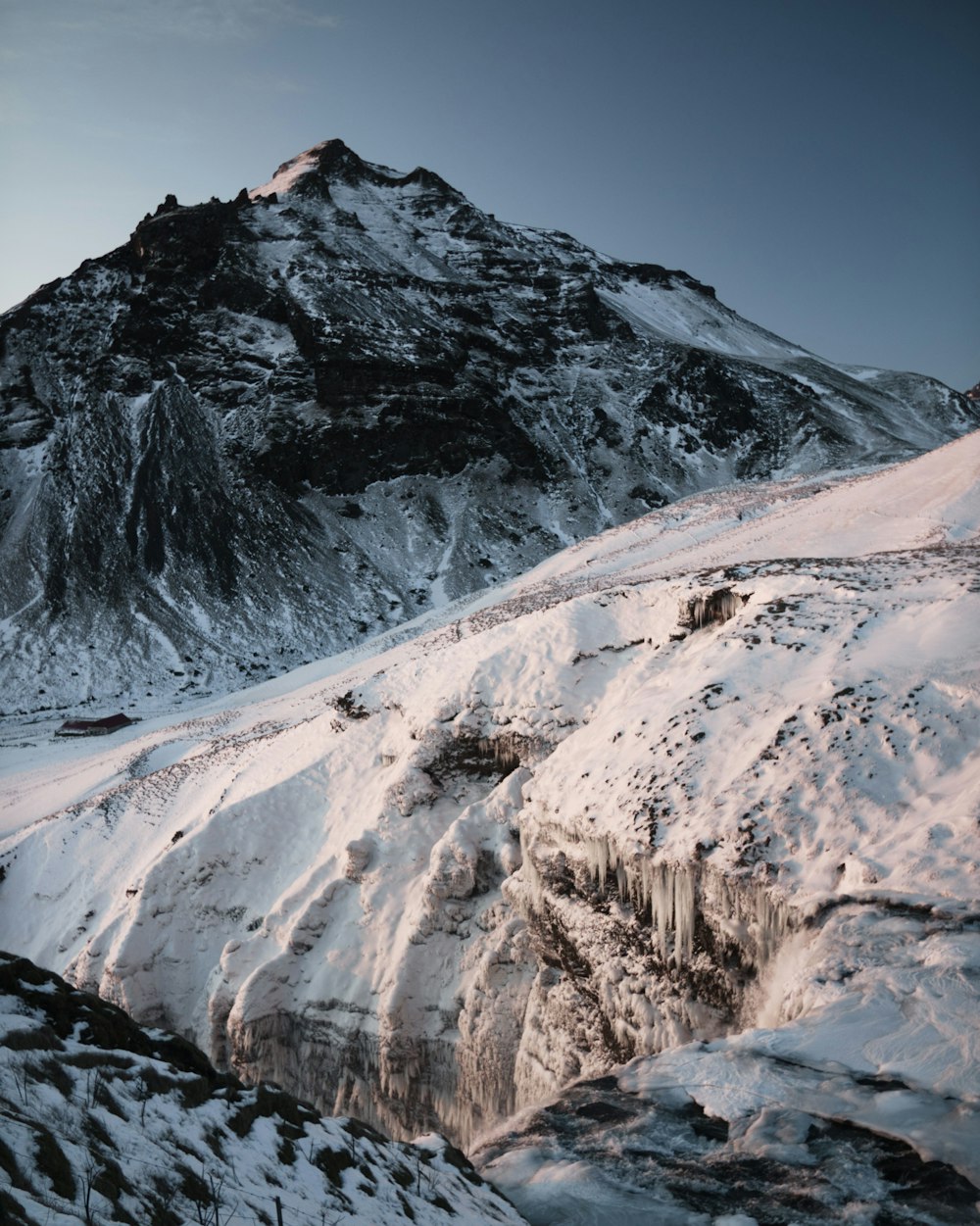 a mountain covered in snow with a sky background