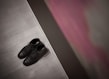 A pair of sleek leather shoes placed on a wooden surface with a blurred background.