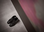 A pair of sleek leather shoes placed on a wooden surface with a blurred background.