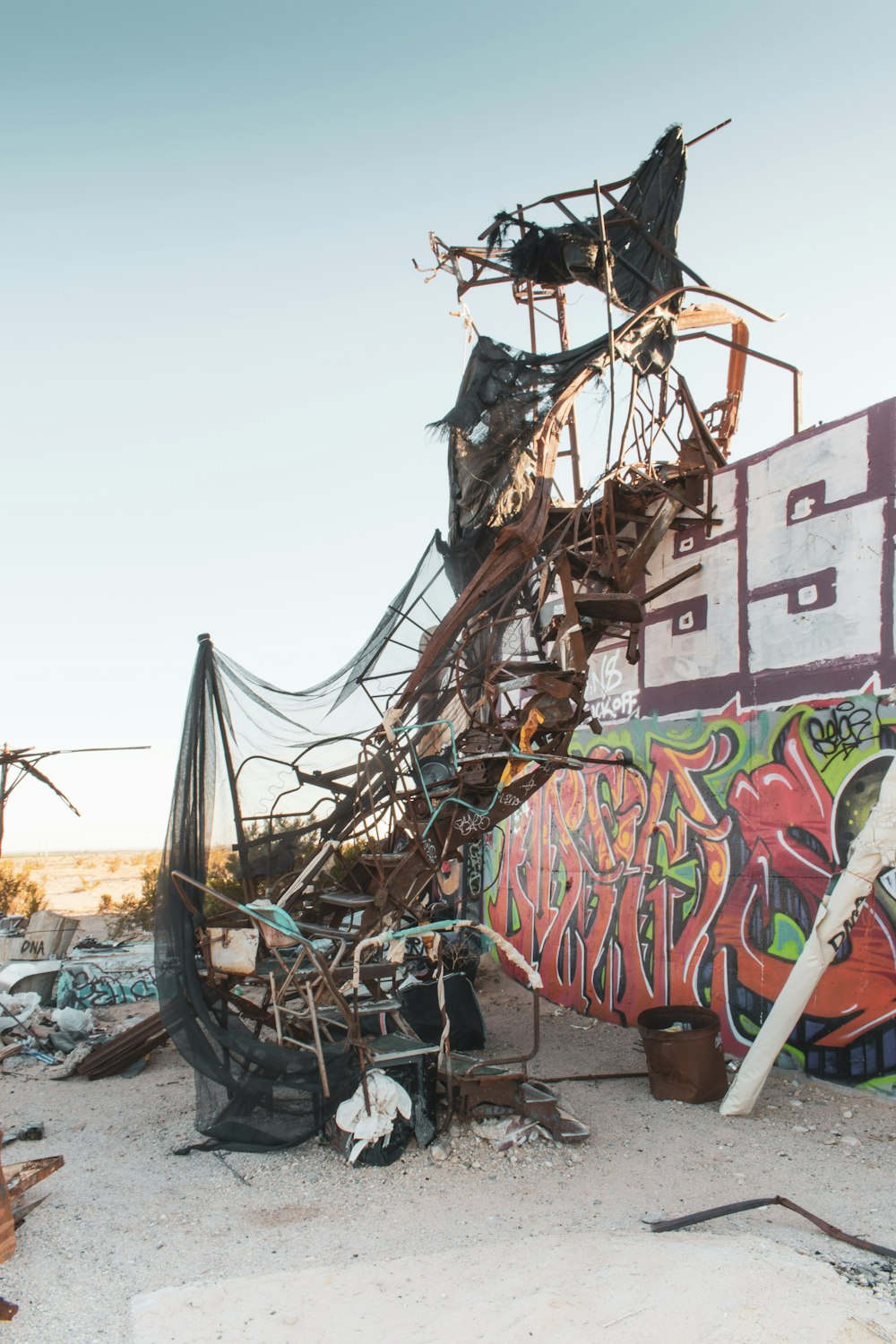 a pile of junk sitting next to a wall covered in graffiti