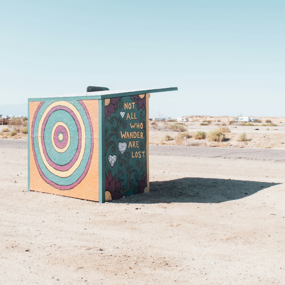 a colorful box sitting in the middle of a desert