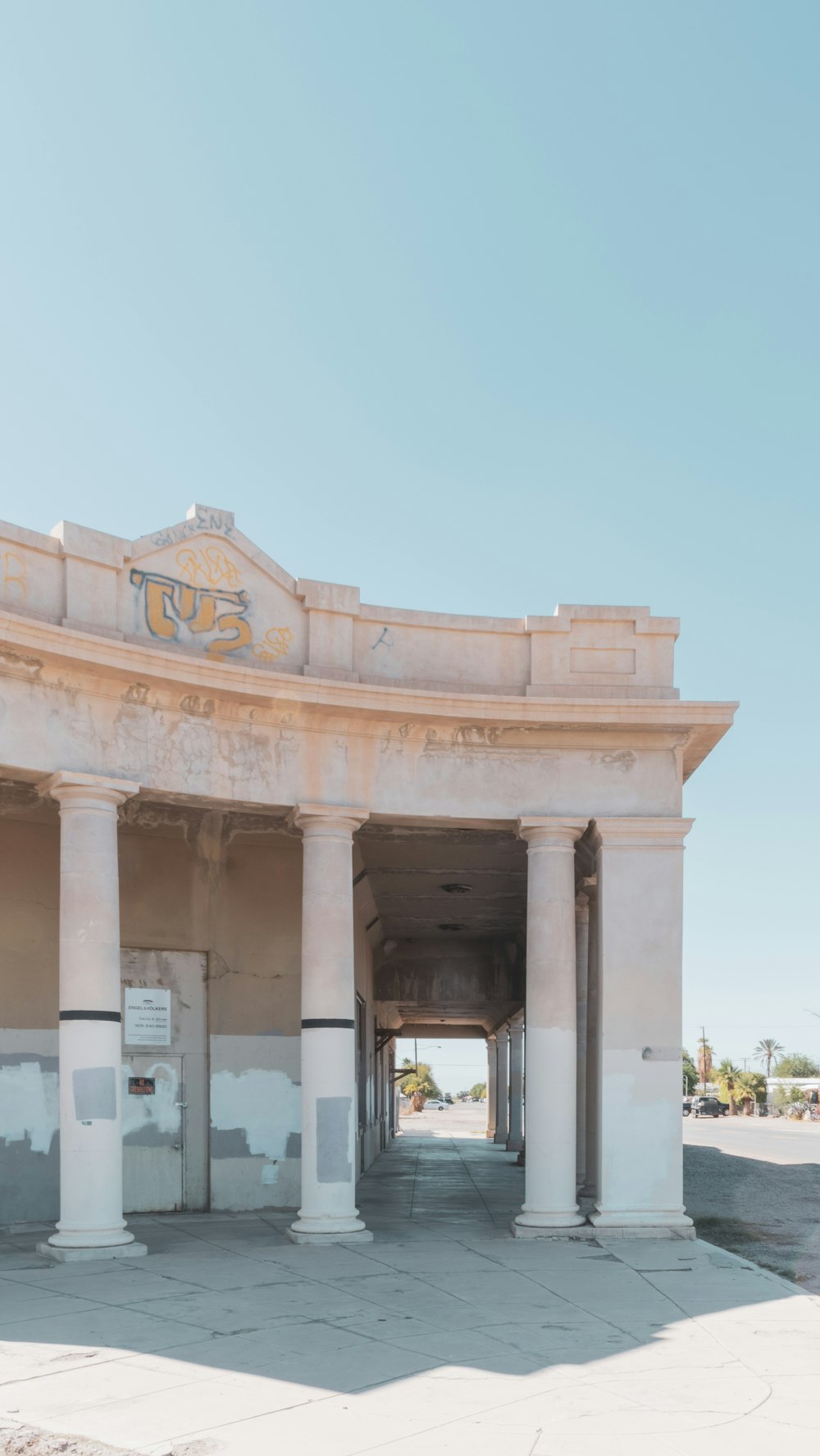 a building with pillars and a clock on the top of it