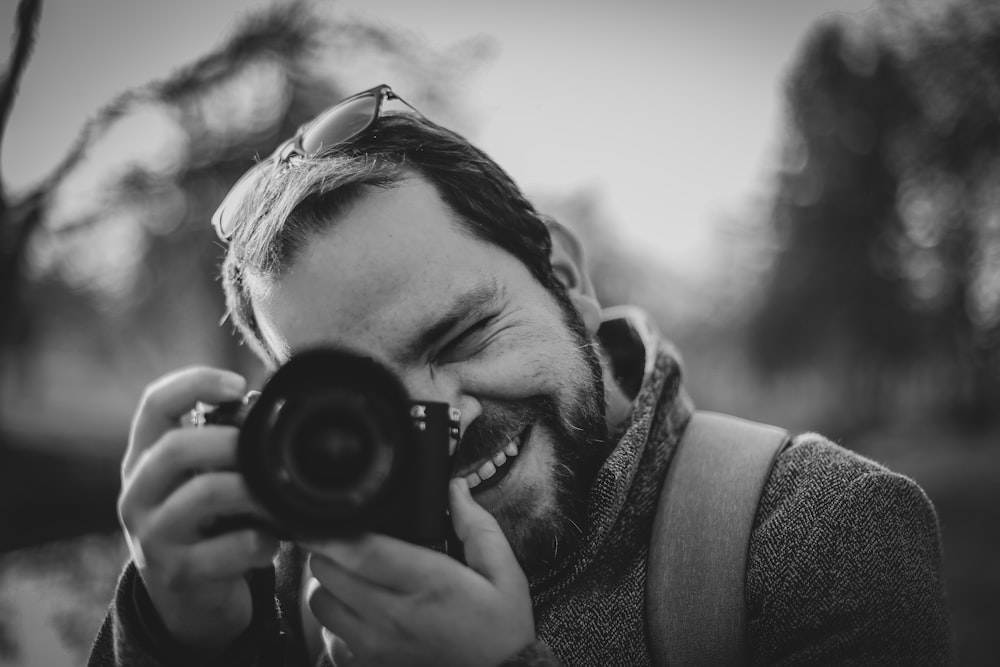 grayscale photo of woman holding camera