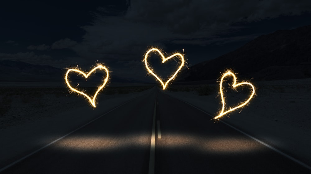 white light forming heart on snow field during night time