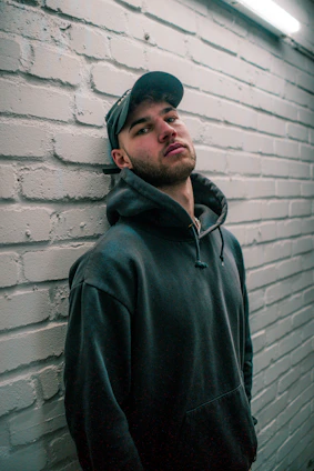 A sleek black hoodie draped over a dark gray concrete bench under soft urban lighting.