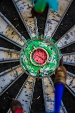 A lively darts game in progress with players aiming at a brightly lit dartboard.