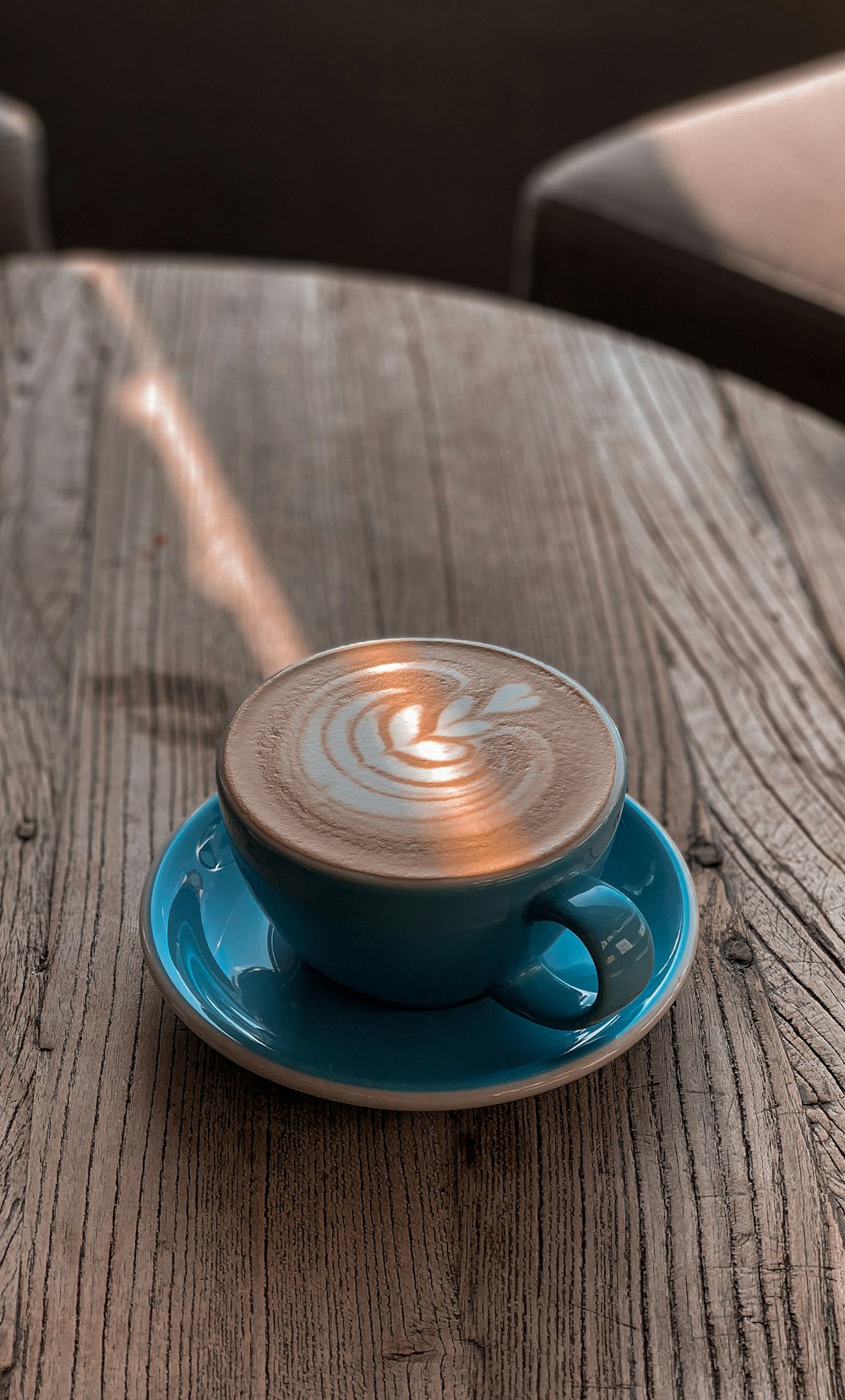 blue ceramic cup with saucer on brown wooden table