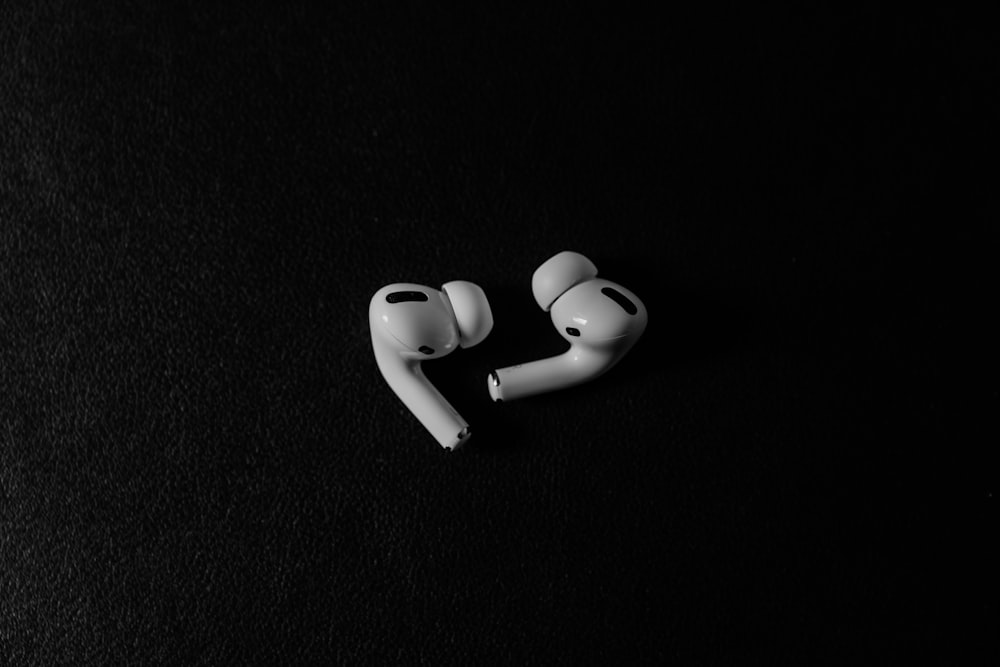 a pair of ear buds sitting on top of a black surface