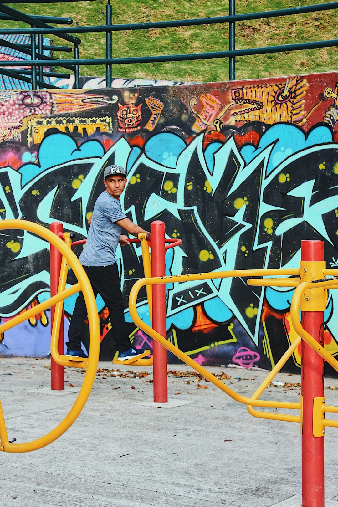 woman in gray long sleeve shirt standing beside graffiti wall during daytime
