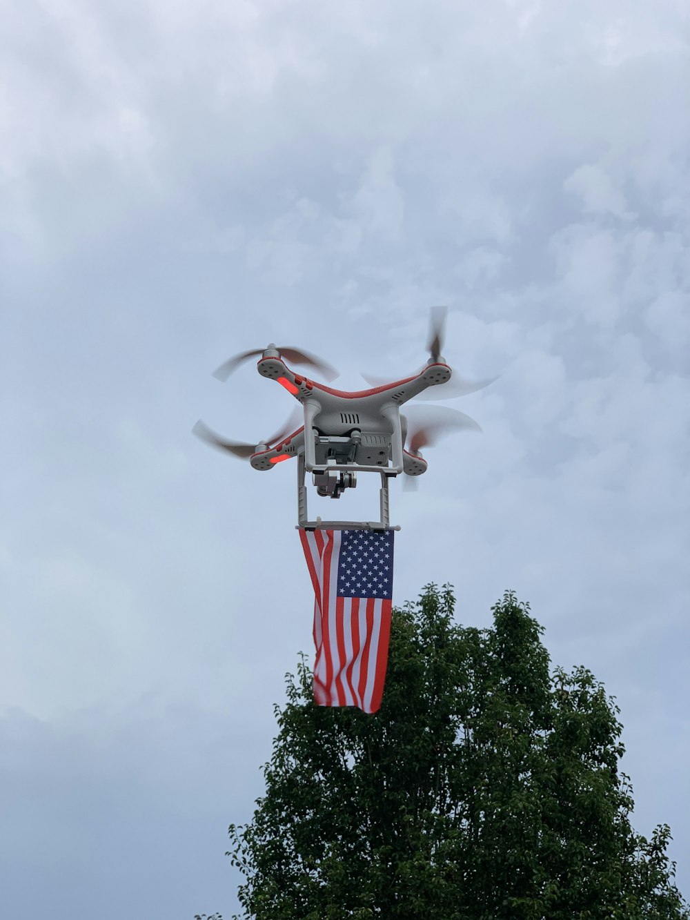 man in white t-shirt and red and white striped pants jumping over green tree during