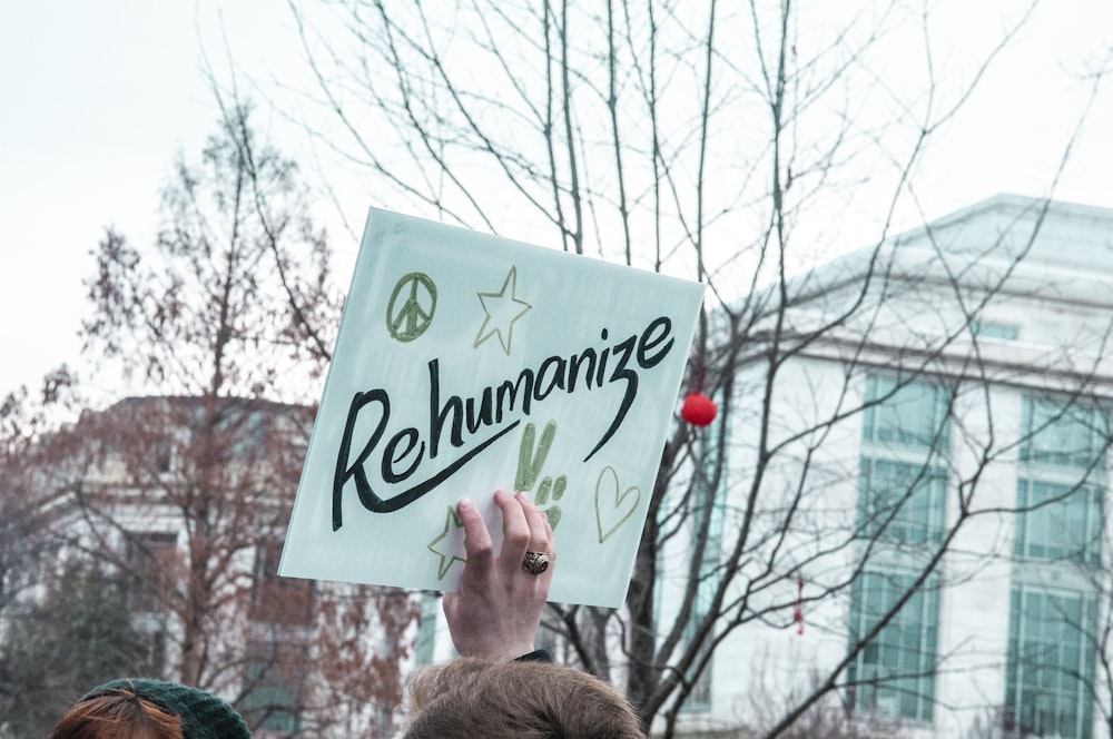 person holding white and green happy birthday signage