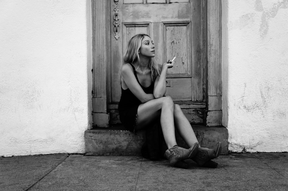 a black and white photo of a woman smoking a cigarette