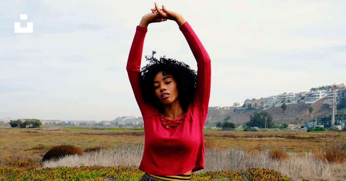 A woman standing in a field with her arms above her head photo – Free ...