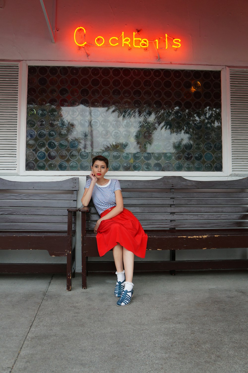 a woman sitting on a bench in front of a building