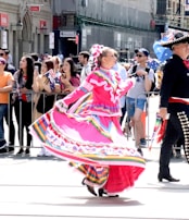 A candid shot of a woman in a vibrant dress dancing joyfully at an outdoor event.