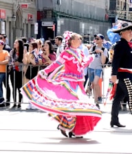 Crowd dancing joyfully at a colorful outdoor Mexican regional music festival.