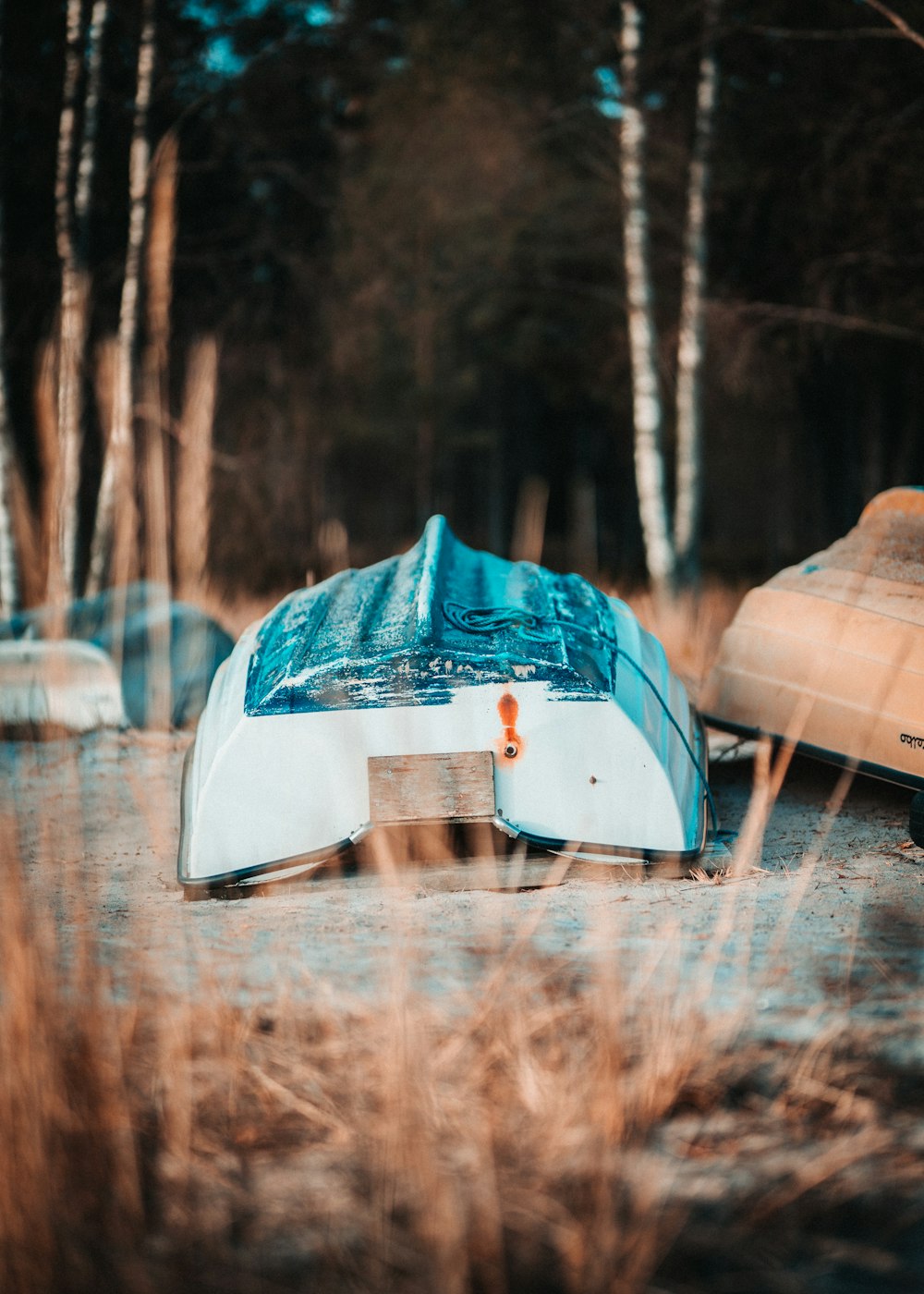 a couple of boats that are sitting in the grass