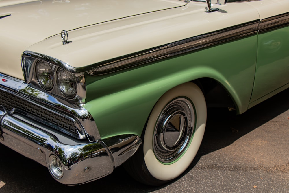 a green and white classic car parked in a parking lot