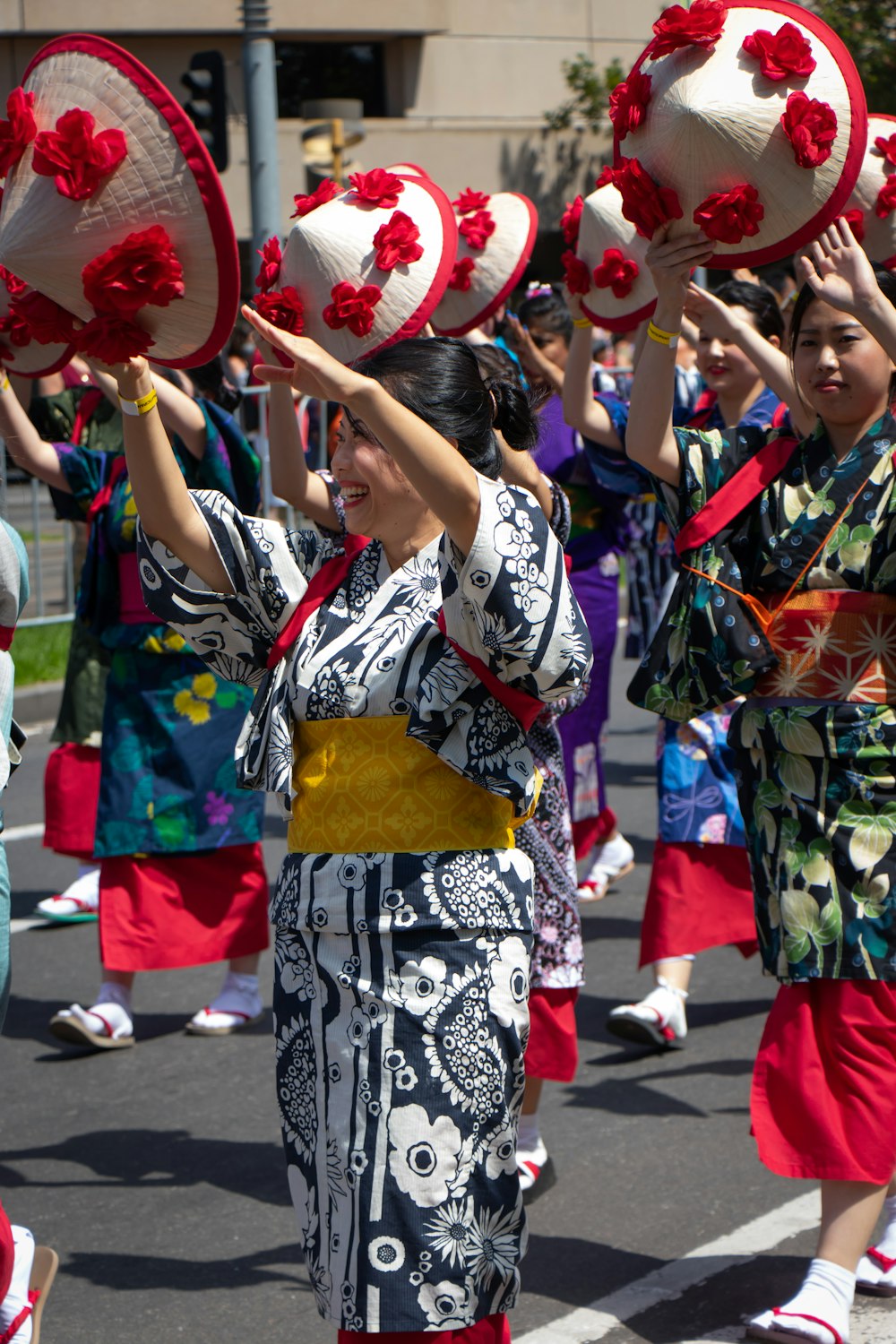 a group of women in kimonos and hats marching down a street