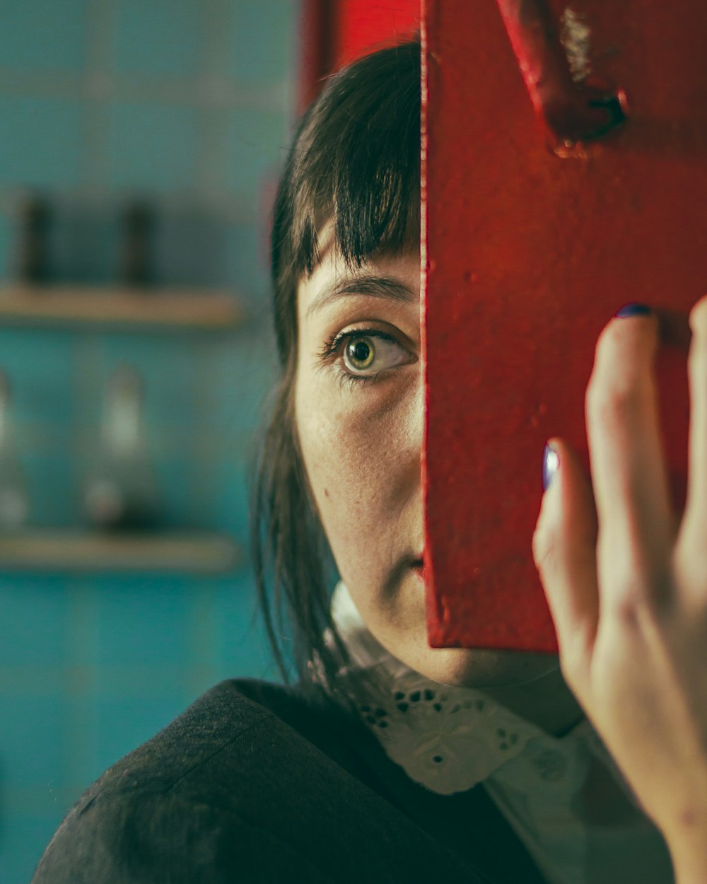 a woman holding a red object up to her face