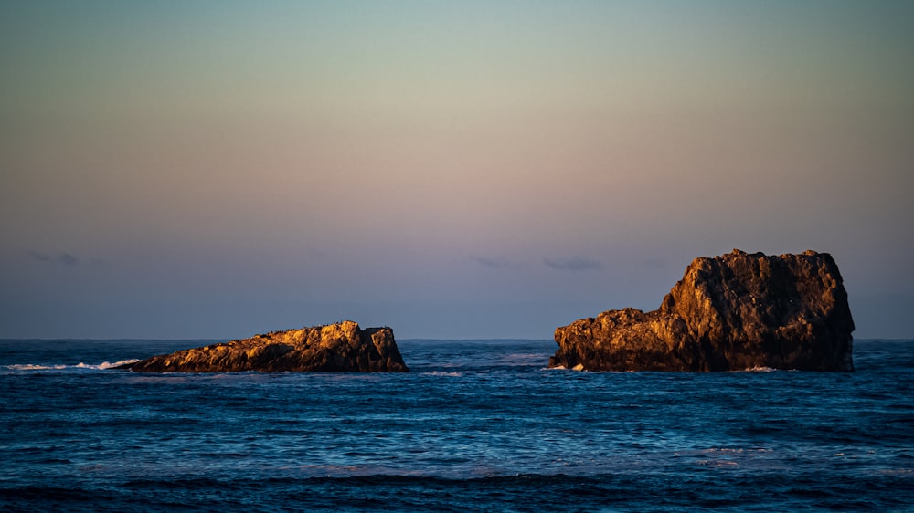 two large rocks in the middle of the ocean