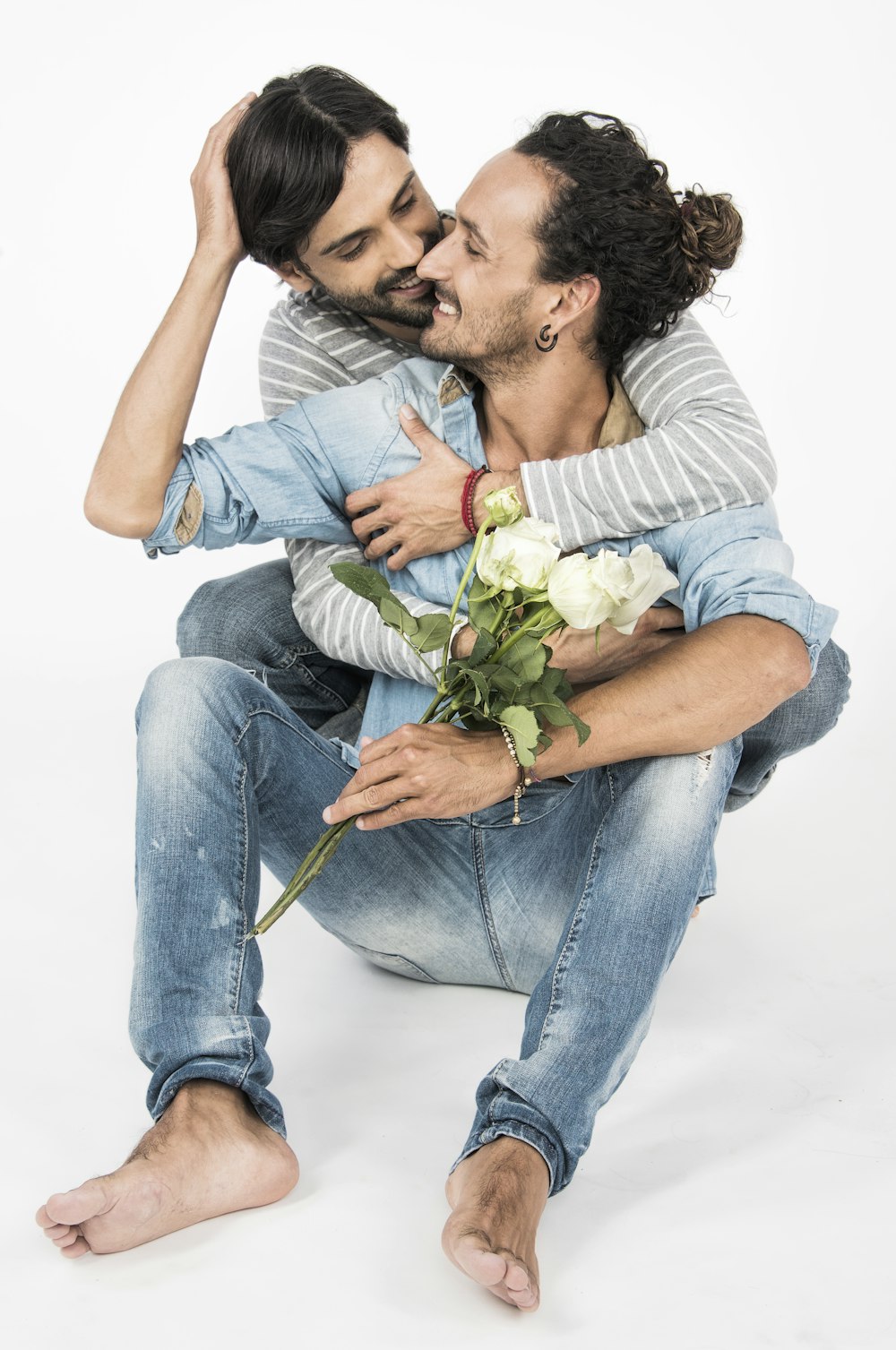 a man sitting on the ground holding a bouquet of flowers