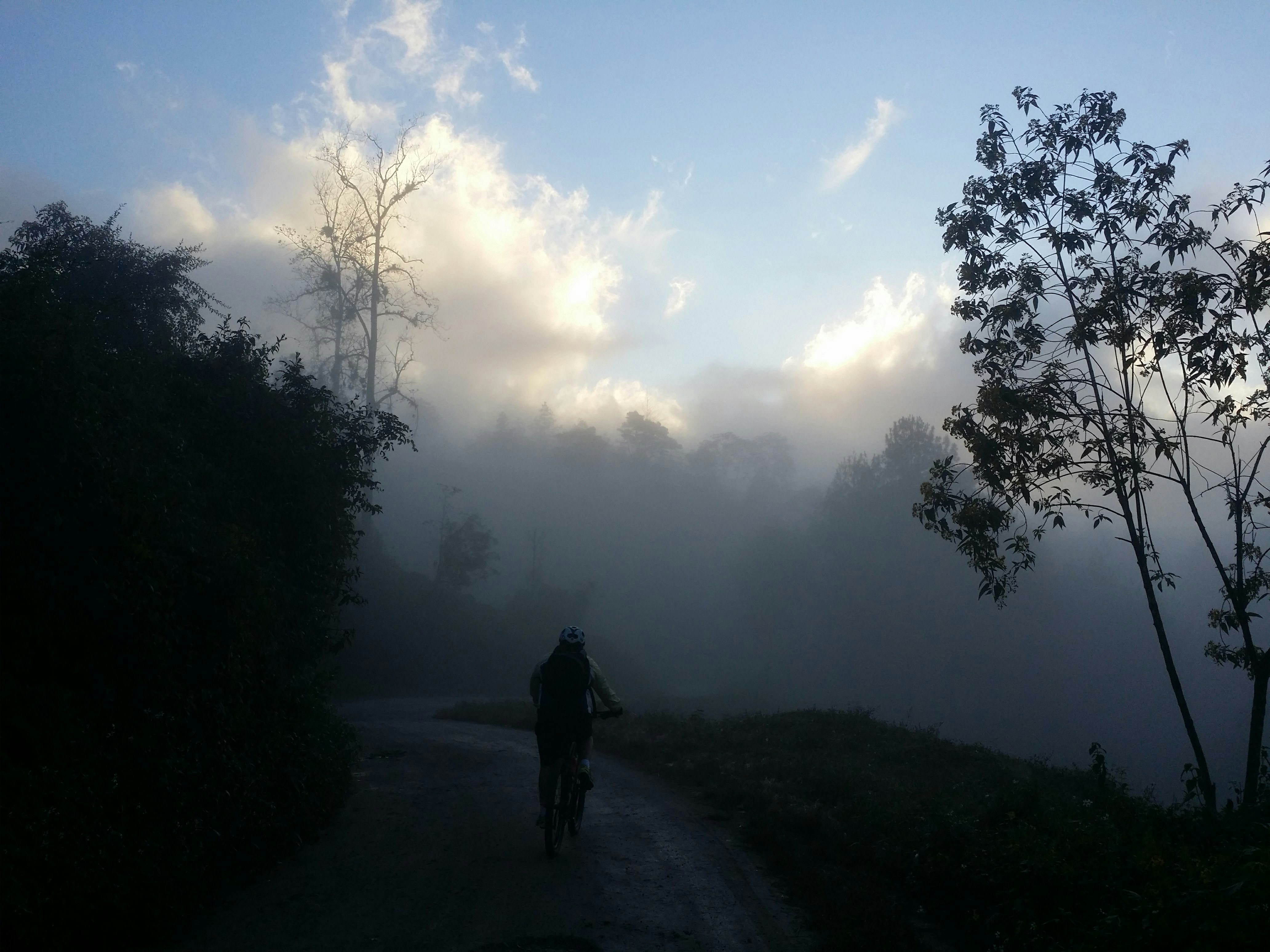 a person riding a bike down a dirt road