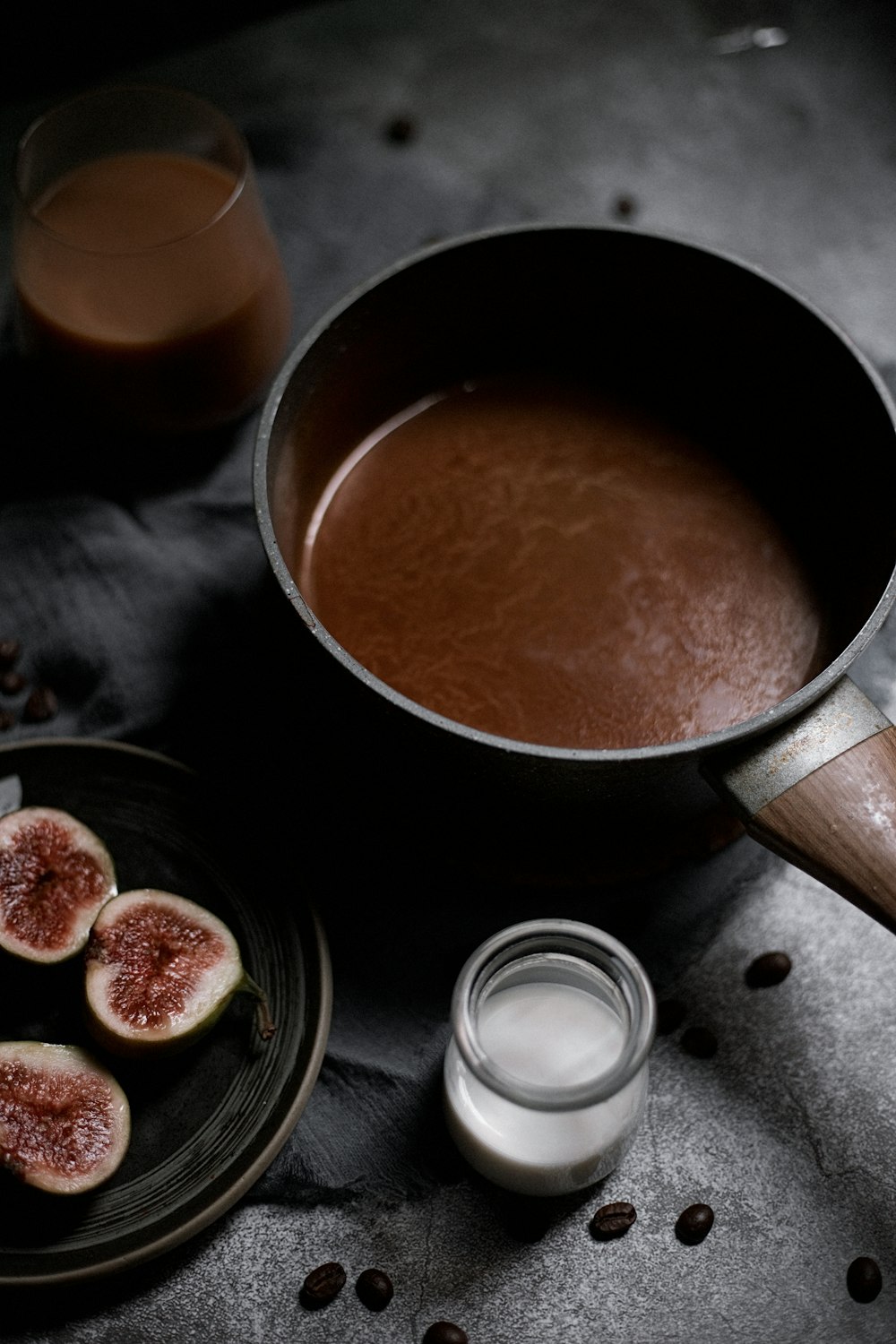 a pan of chocolate pudding with figs on a plate
