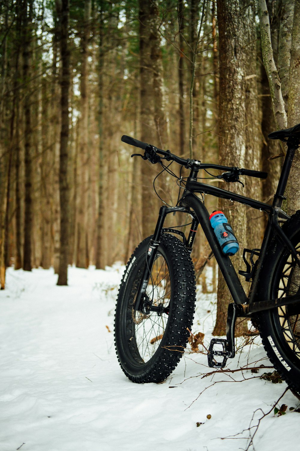 a mountain bike parked in the snow in the woods