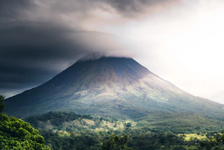 a very tall mountain with a very cloudy sky above it