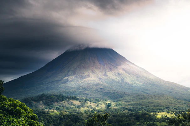 a very tall mountain with a very cloudy sky above it