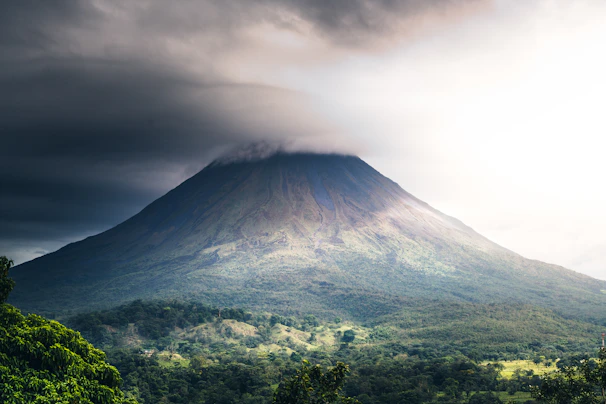 a very tall mountain with a very cloudy sky above it
