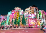 a group of people walking around a city at night