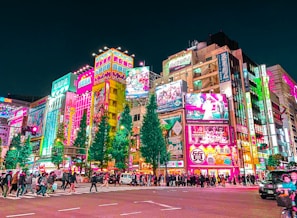 a group of people walking around a city at night