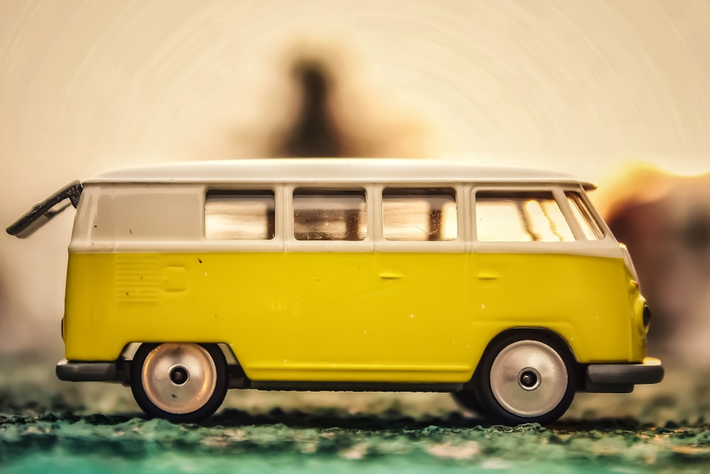 a yellow and white toy bus sitting on top of a table
