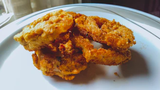 A neat row of onion rings, perfectly fried and golden brown on a white plate.