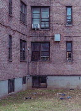 Wide shot of an apartment building with multiple pigeon nets installed on windows.