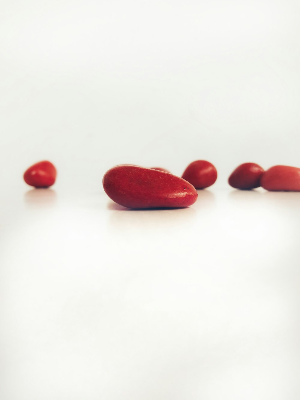 a group of red beans sitting on top of a white table