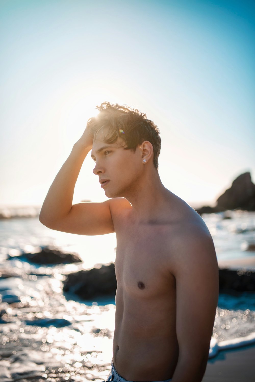 a man standing on a beach next to the ocean