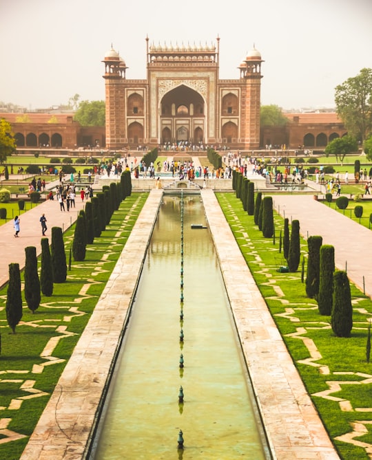 people walking on green grass field during daytime in Taj Mahal India
