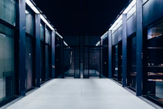 a long hallway with glass doors leading to another room
