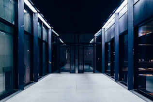 a long hallway with glass doors leading to another room