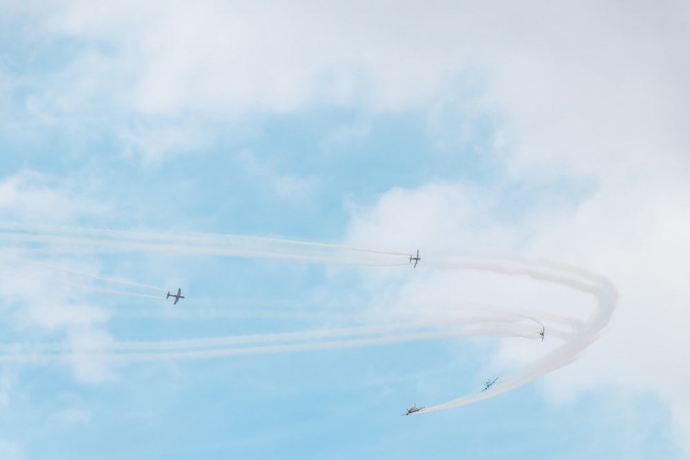 a group of airplanes flying through a cloudy blue sky