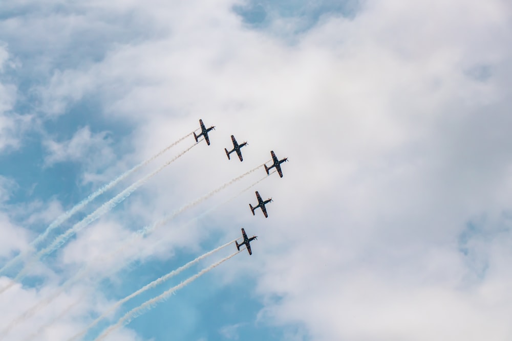 four airplanes are flying in formation in the sky