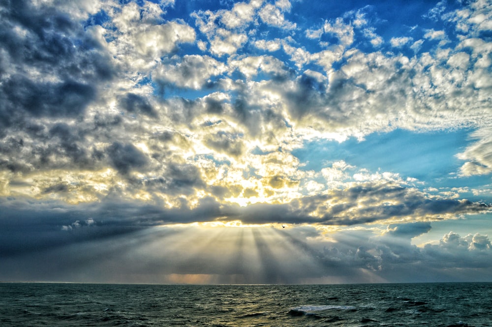 the sun is shining through the clouds over the ocean