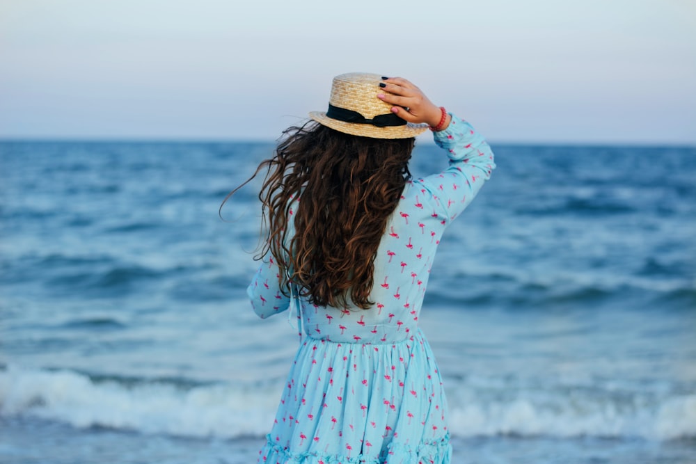 a woman with long hair standing on the beach