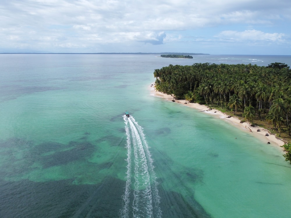 a boat is traveling through the water near a beach