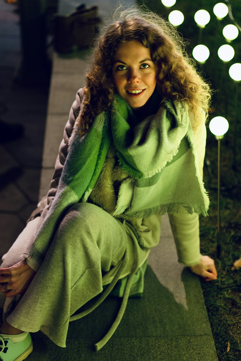 a woman sitting on the ground next to some lights