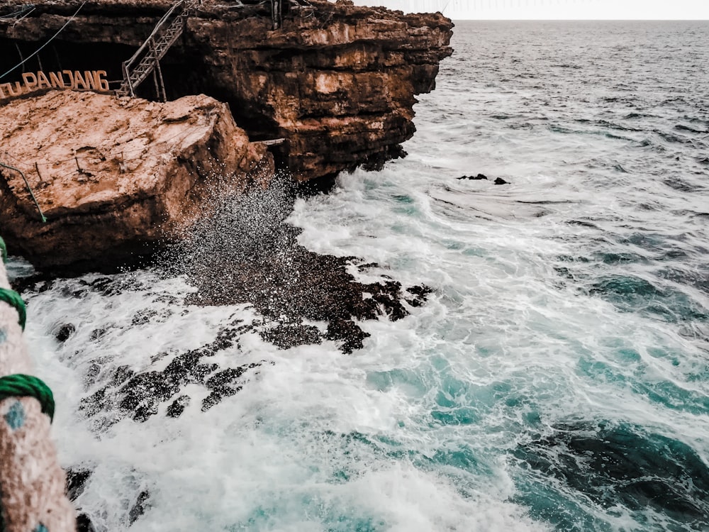 Un acantilado rocoso junto al océano con una cuerda