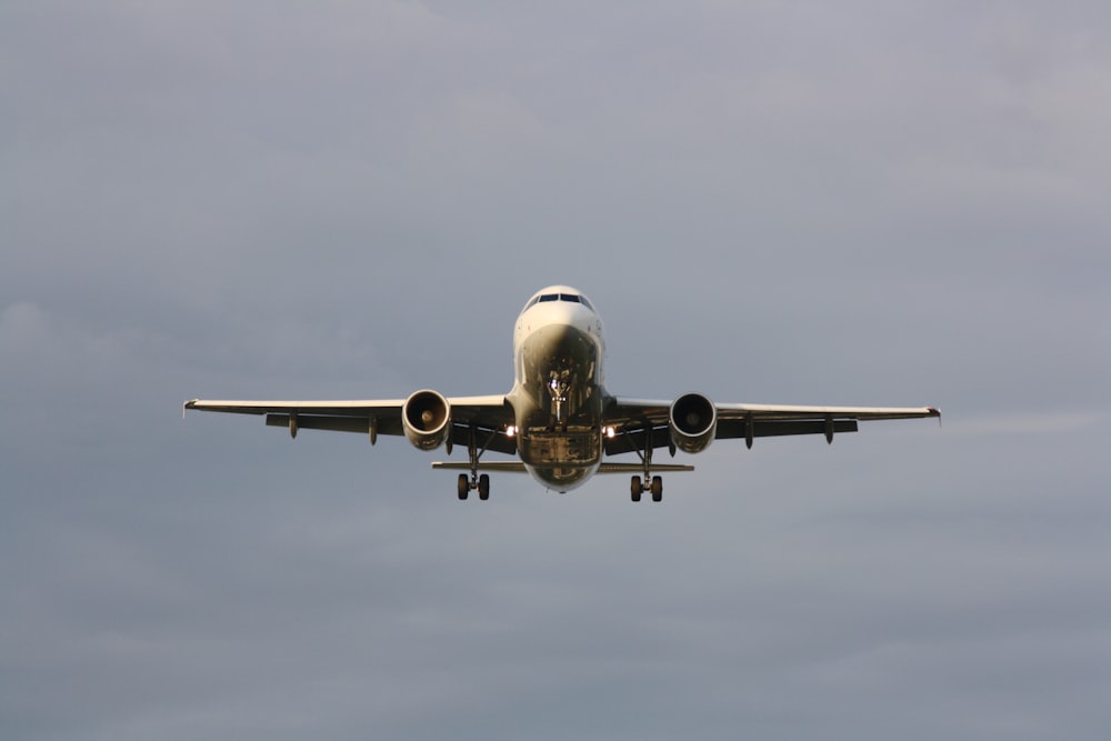 white airplane in mid air during daytime